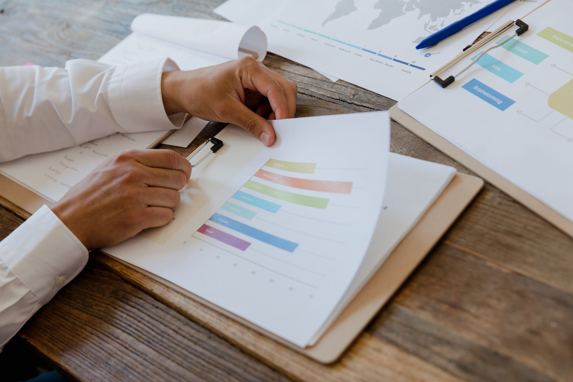 Hands reviewing printed charts at a desk