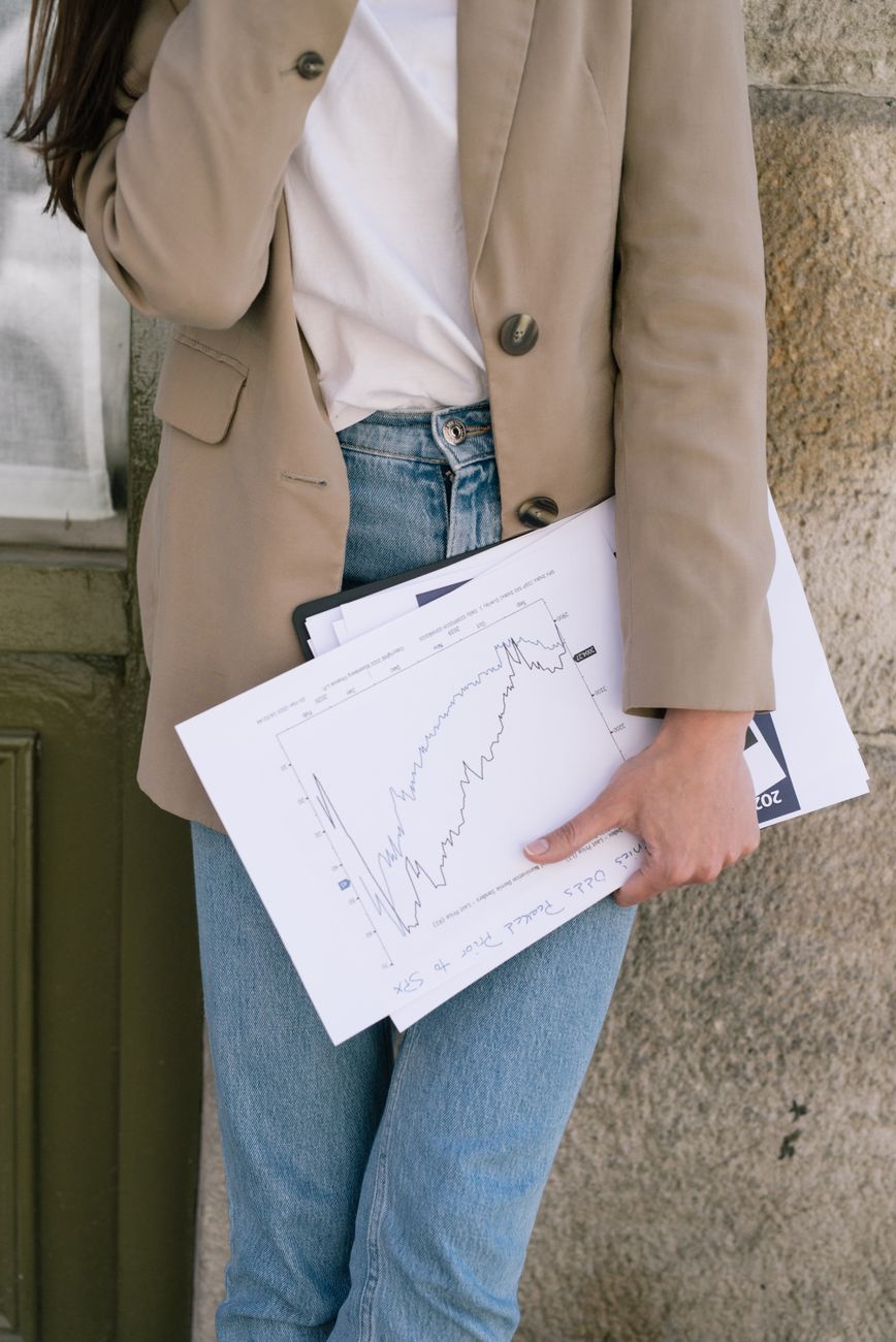 Person holding documents outdoors